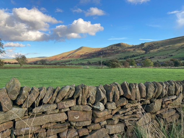 View of the surrounding hills with a traditional stone wall in the foreground.